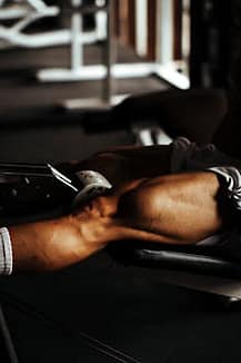 pexels-photo-13315489-13315489 Focused view of a man's muscular legs during a gym workout in București.