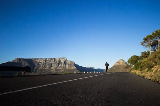 Comprendre les seuils physiologiques en course à pied : Clé de la progression Man jogging along a scenic road with Table Mountain view in Cape Town.