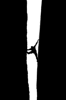 Services Dramatic silhouette of a climber scaling Pennadomo's narrow rock crevice, showcasing strength and balance.