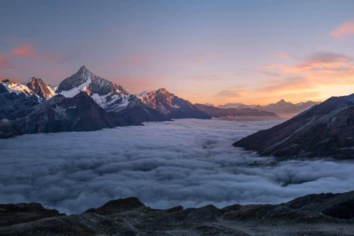 Photo par Samuel Ferrara sur Unsplash Mountains above clouds at sunrise